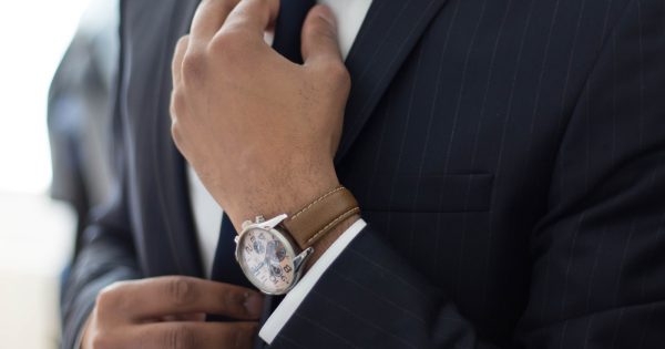 man wearing watch with black suit