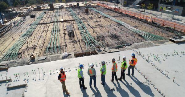 seven construction workers standing on white field